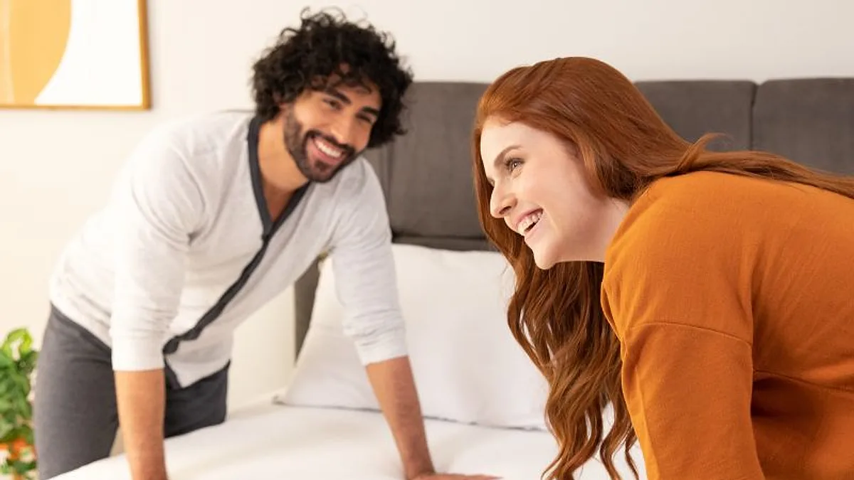Casal apoiando as mãos no colchão para sentir a firmeza