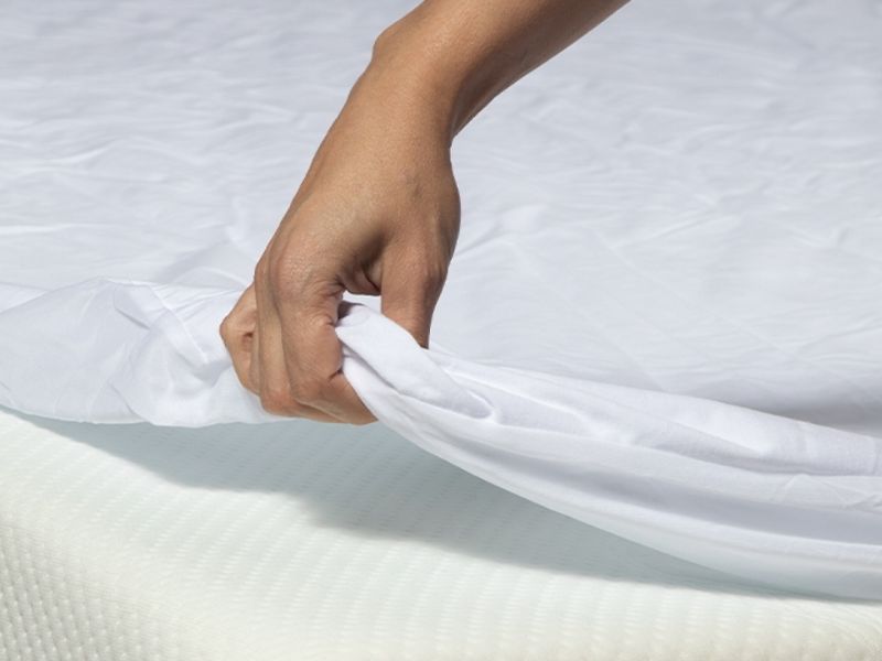 Protetor de colchão impermeável esticado sobre a cama